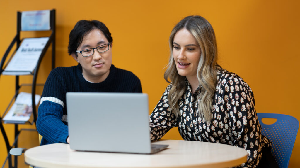 Two members of Home Office staff at a laptop